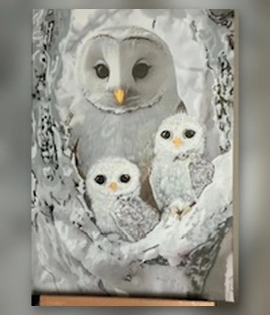Owl family resting inside a snowy tree hollow